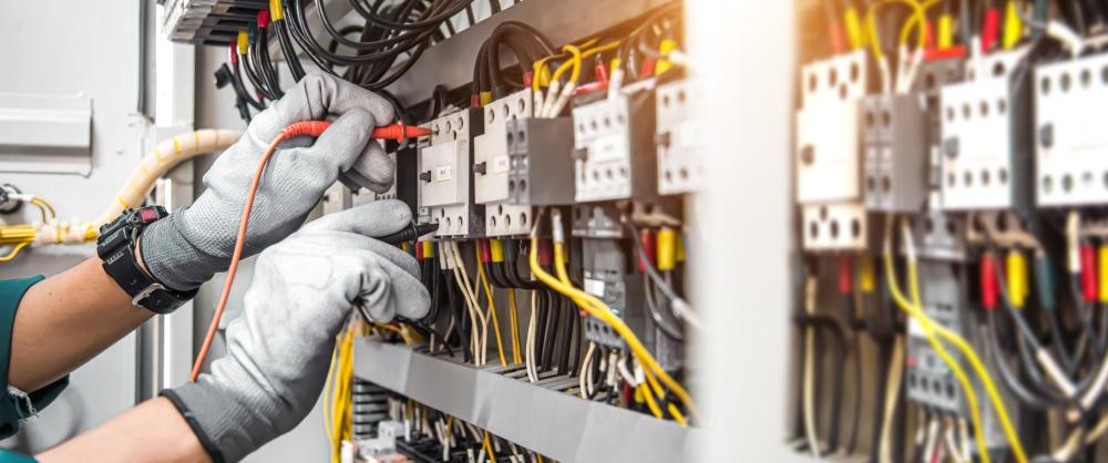 lectricien travaillant sur un tableau électrique